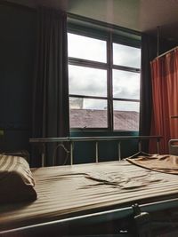 Empty chairs and table against sky seen through window