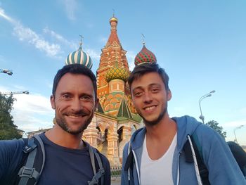 Portrait of smiling young man standing against sky