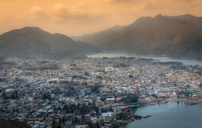 High angle view of townscape by mountains against sky