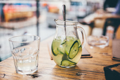 Lemonade in pitcher on wooden table at restaurant