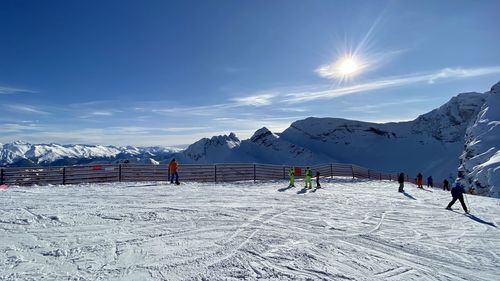 People on snow covered mountain against sky