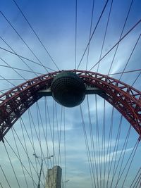 Low angle view of suspension bridge against cloudy sky