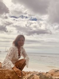 Woman on beach by sea against sky