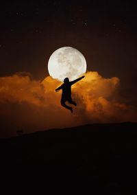 Silhouette man against moon at sunset