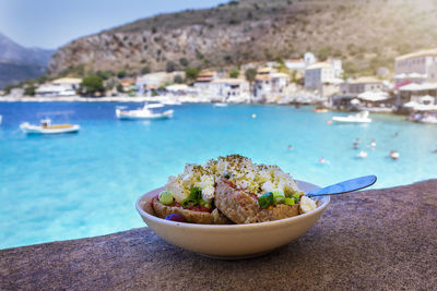 Close-up of food on table by sea