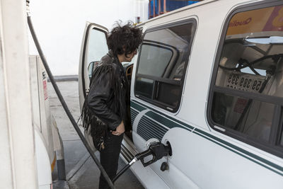 Young man pumping gas