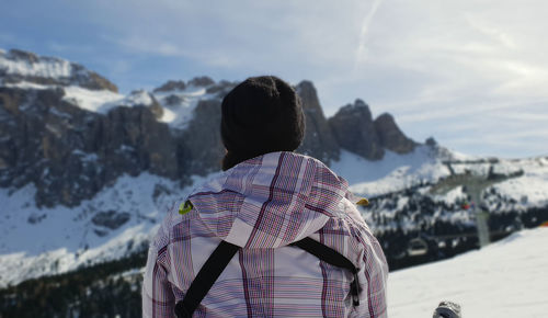 Rear view of woman standing on snowcapped mountain