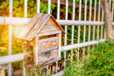 Close-up of abandoned wooden birdhouse on railing