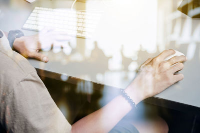 Midsection of man using computer at table