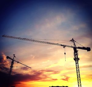 Low angle view of silhouette crane against sky during sunset