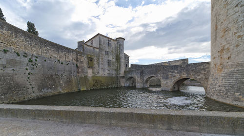 Arch bridge over canal against sky