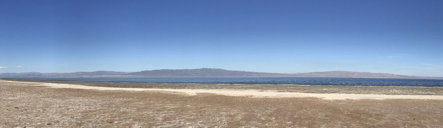 Scenic view of beach against clear blue sky