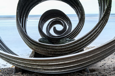 Close-up of spiral staircase at beach against sky