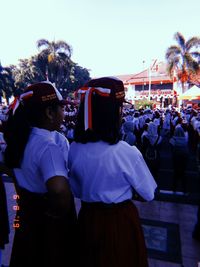 Rear view of people standing against the sky