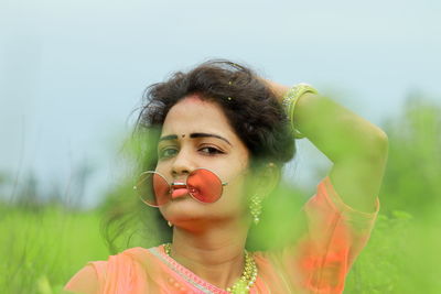 Portrait of young woman on field