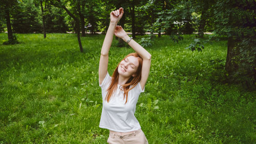 Full length of young woman standing on grass