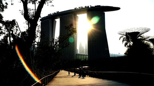 Sun shining over buildings and trees in city