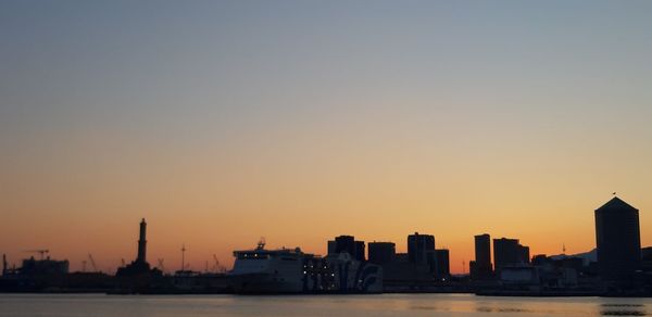 Silhouette buildings against clear sky during sunset