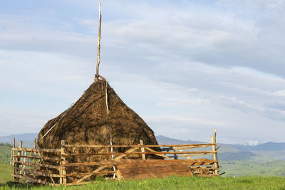 Traditional windmill on field against sky