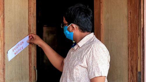 Side view of senior woman standing on entrance
