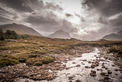 Scenic view of mountains against cloudy sky