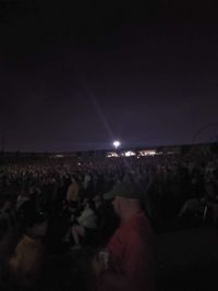 Crowd at music concert against sky at night