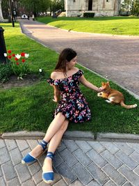 Woman petting cat while sitting at park