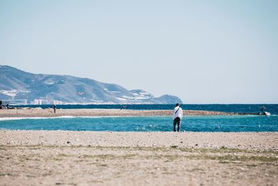 Rear view of man standing at beach