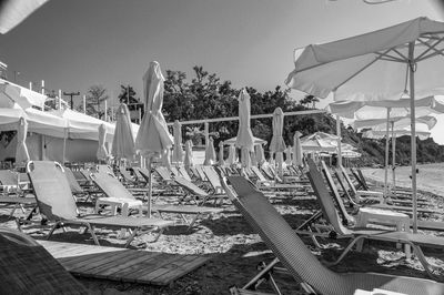 High angle view of empty chairs and tables against clear sky