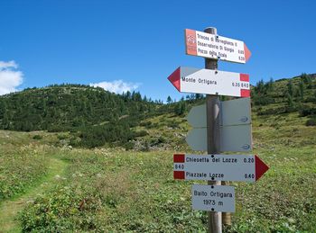 Information sign on field against sky