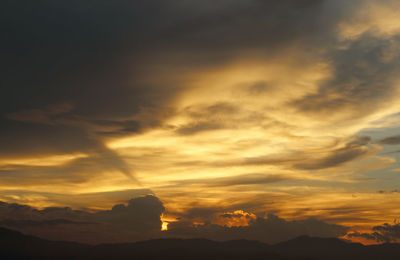 Low angle view of silhouette mountains against orange sky