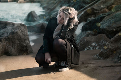 Woman kneeling at beach