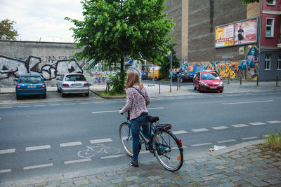 Rear view of woman cycling on street