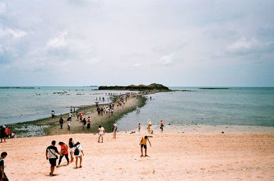 People at beach against sky