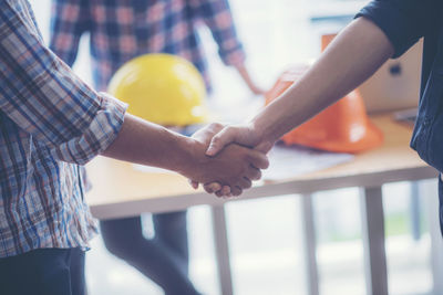 Midsection of couple holding hands