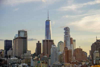 Skyscrapers in city against cloudy sky