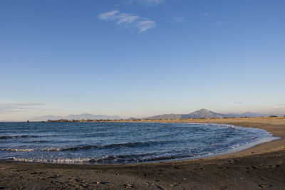 Scenic view of beach against blue sky