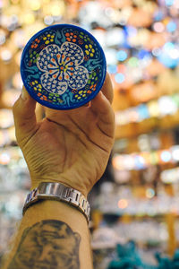 Close-up of man holding multi colored umbrella