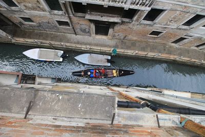 High angle view of boats at canal by building