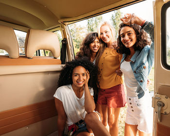 Portrait of happy friends sitting in car