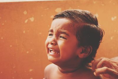 Portrait of cute boy crying during a hair cut