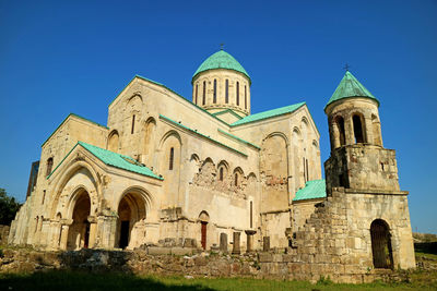 Low angle view of historic building against clear blue sky