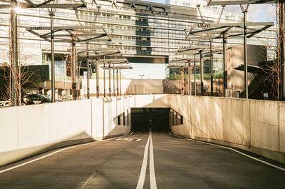 Empty road amidst buildings in city