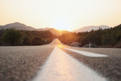 Surface level of road against sky during sunset