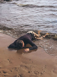 Man lying down on sand at beach