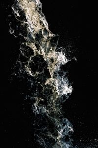 Close-up of water splashing against black background