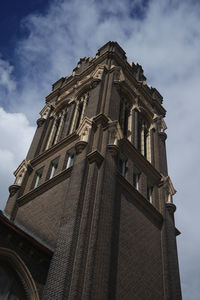 Low angle view of bell tower against cloudy sky