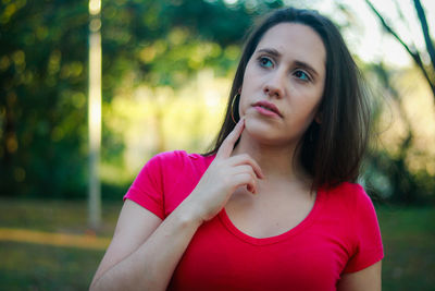 Close-up of beautiful young woman against trees