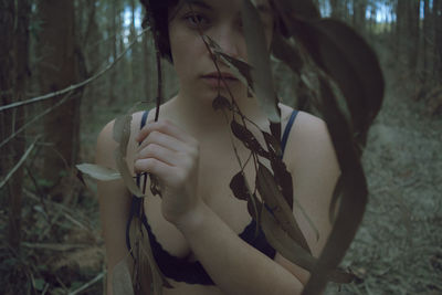 Portrait of woman by plants in forest