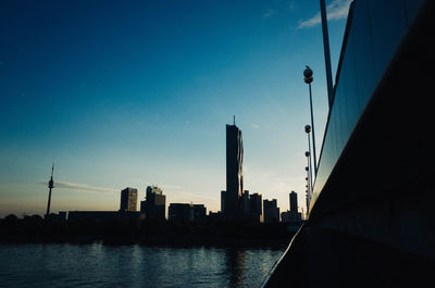 City at waterfront against blue sky
